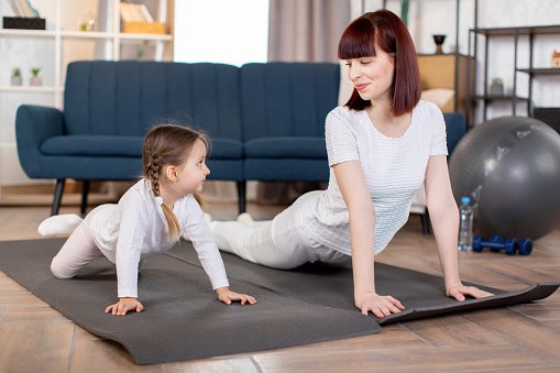 Busy mother doing a quick home workout in her living room, representing realistic fitness, healthy habits, and self-care for moms with busy lifestyles.